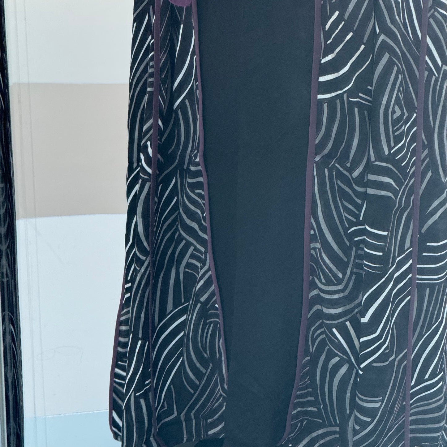 A black abaya with white and maroon lines satan fabric