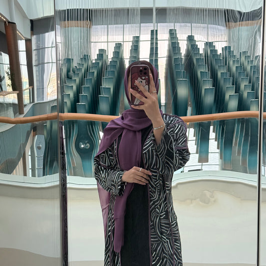 A black abaya with white and maroon lines satan fabric